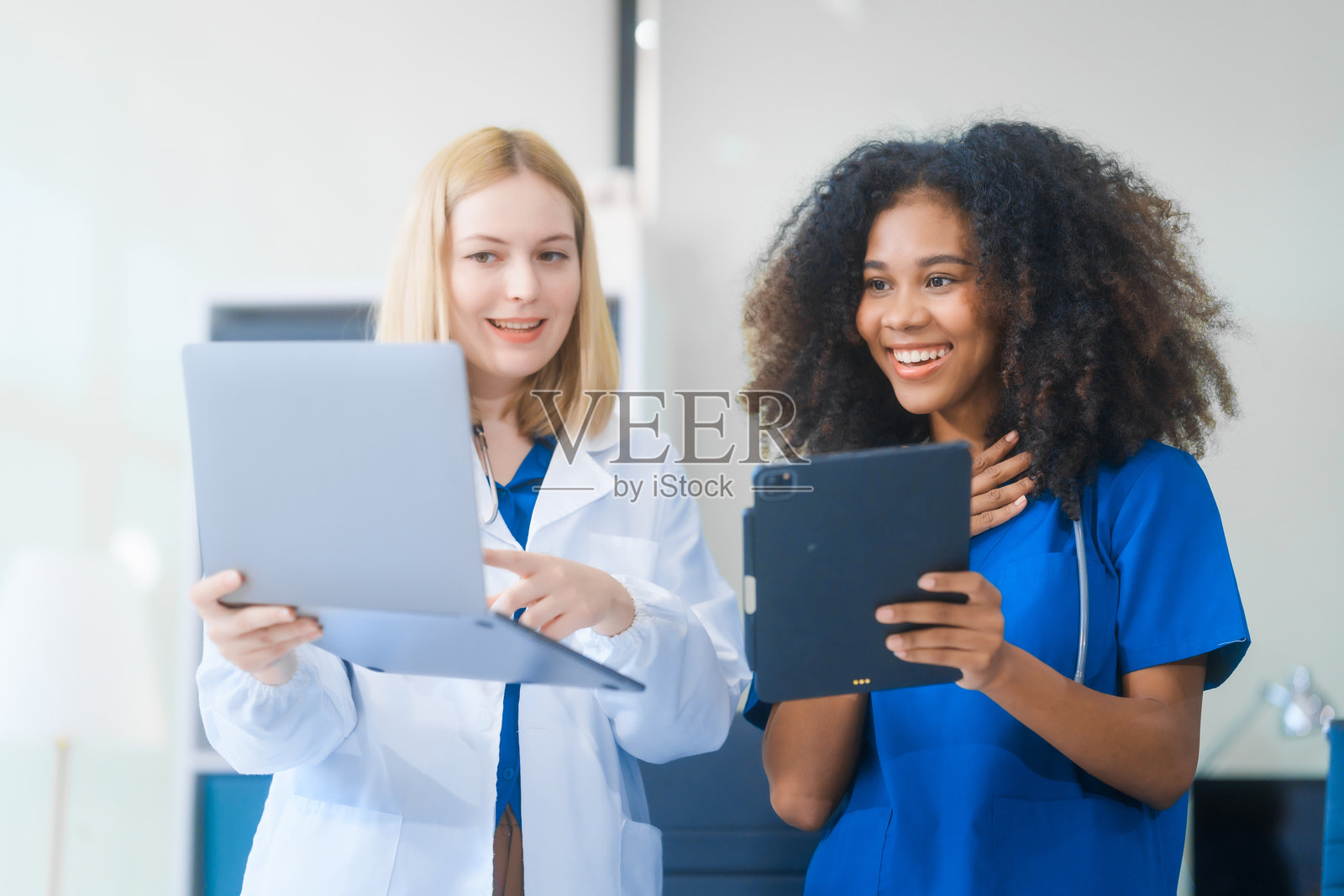 年轻的非裔美国女性和俄罗斯女性，都是科学家，合作分析血样、病毒和疫苗，使用显微镜进行重要的医学和生物研究。照片摄影图片