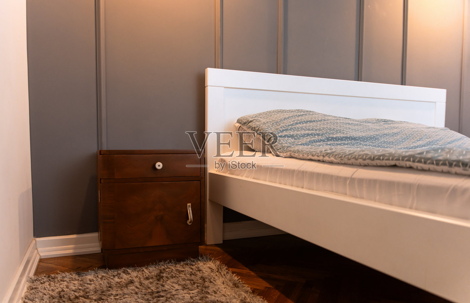 复古木质床头柜放在床旁。照片摄影图片