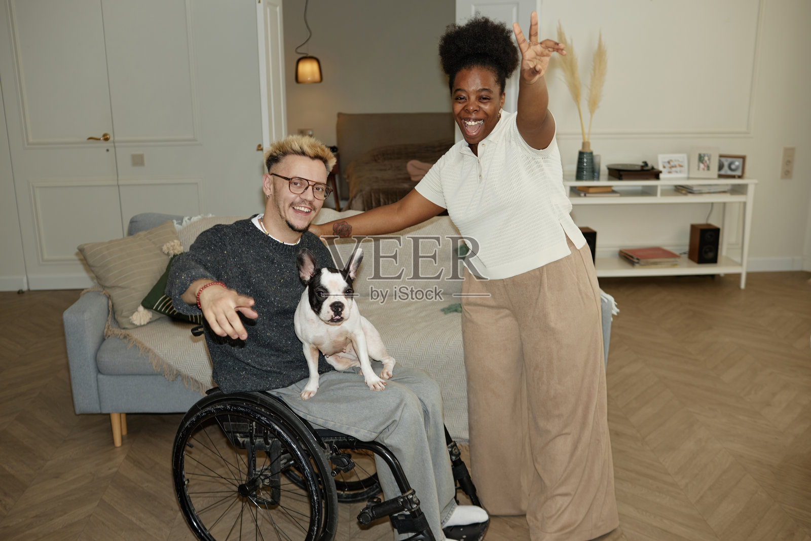 一位微笑灿烂的黑人女性在家中与使用轮椅的男性合影照片摄影图片