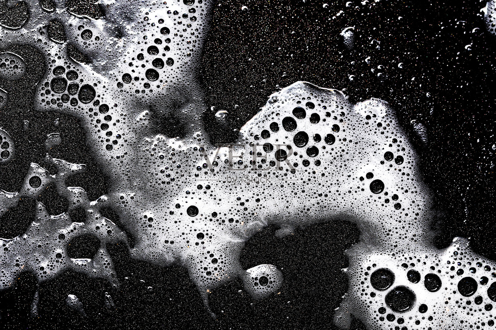 泡沫纹理。黑色背景上的白色气泡。清洗煎锅。照片摄影图片