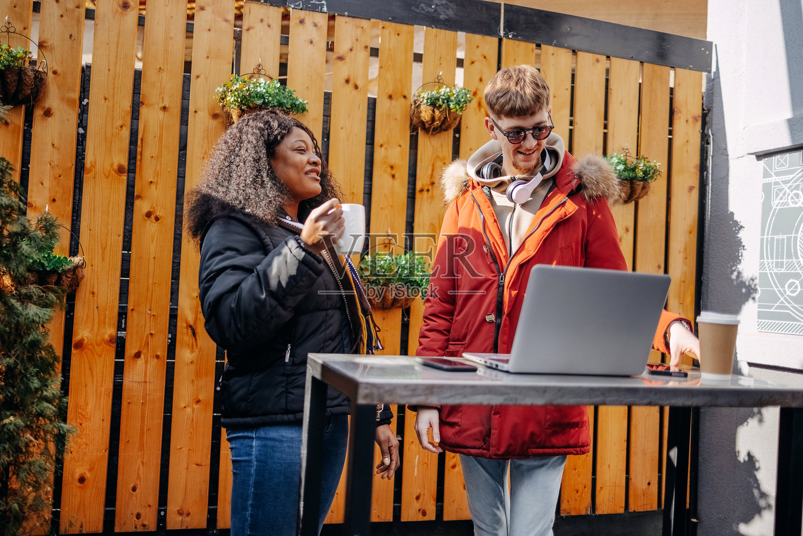 大学生在户外人行道咖啡馆休息，查看笔记本电脑照片摄影图片