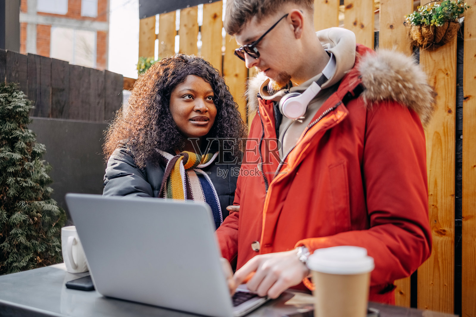 大学生在户外人行道咖啡馆休息，查看笔记本电脑照片摄影图片