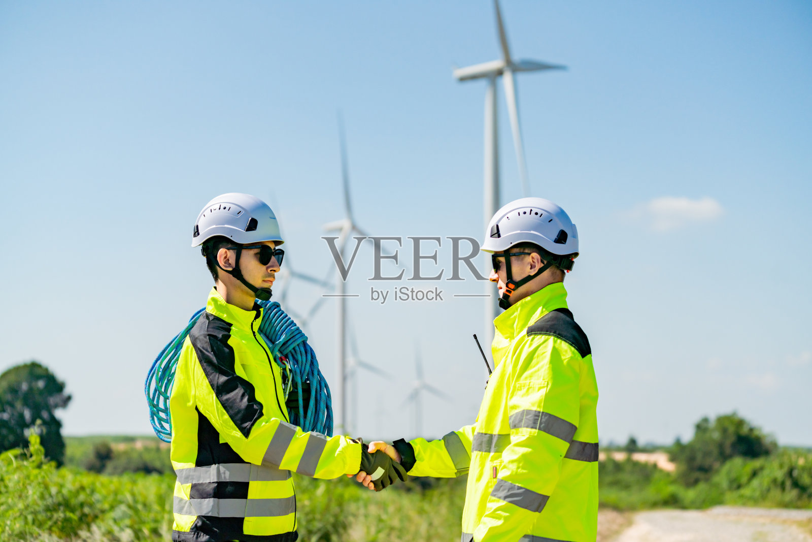 风能工作人员在晴朗的蓝天下穿着安全装备协作作业照片摄影图片