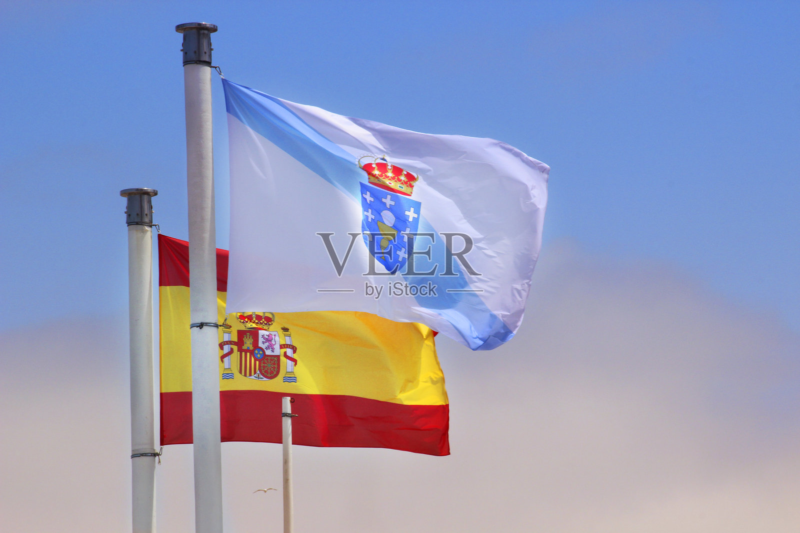 西班牙国旗和加利西亚国旗在风中飘扬照片摄影图片