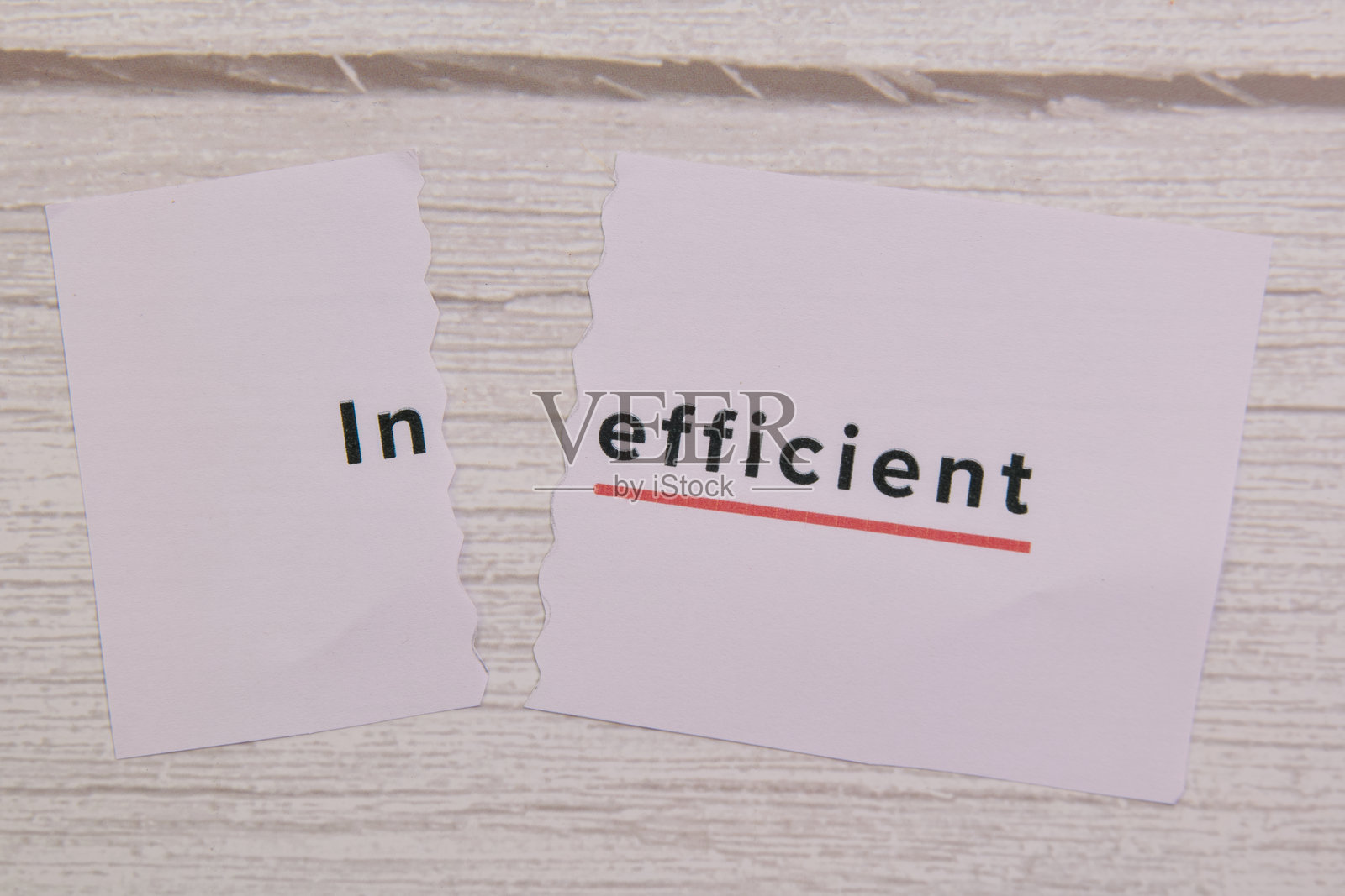 撕裂的纸张上显著显示着“低效”一词照片摄影图片