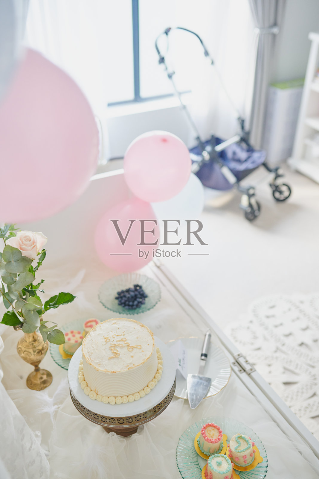 性别揭晓，庆祝活动或装饰蛋糕在桌上用于惊喜宣布，悬念或家庭聚会。俯视图，布置或气球在家中用于婴儿性别、怀孕活动和他或她的甜点。照片摄影图片