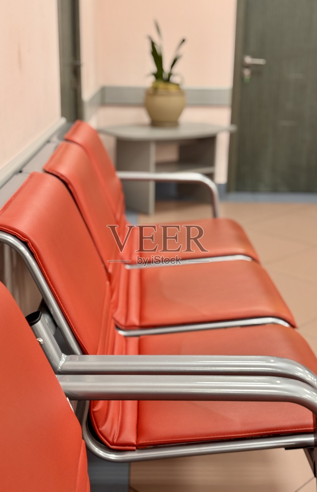 现代候车区，配有红色座椅和郁郁葱葱的绿植，营造出宜人的氛围照片摄影图片