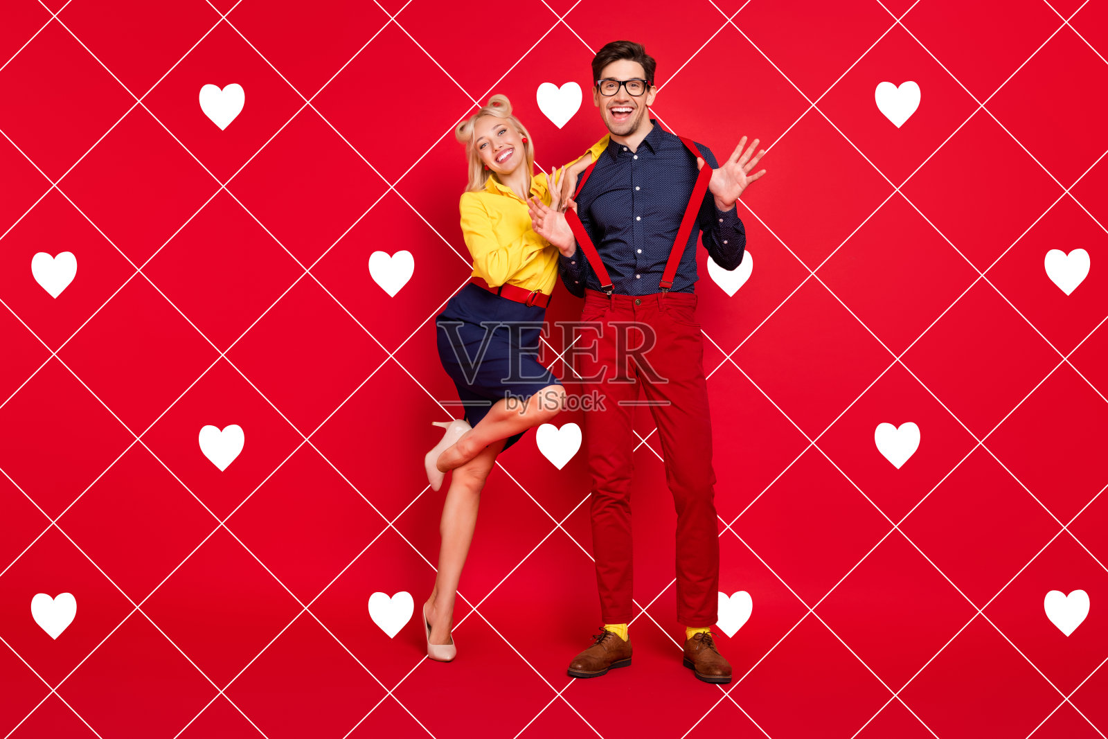 迷人的时尚年轻男女穿着复古服装，微笑着在红色背景下跳布吉舞。照片摄影图片