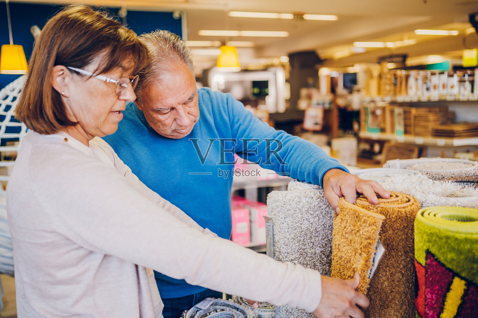 成熟夫妇在家具店挑选地毯照片摄影图片