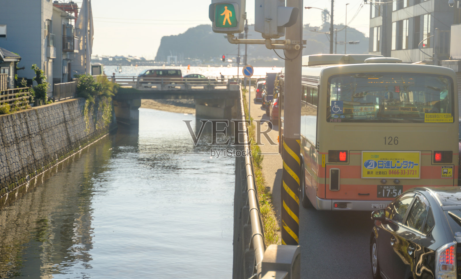 在湘南海岸的镰仓附近，日落时分的城市交通，背景中是小岛江之岛。照片摄影图片