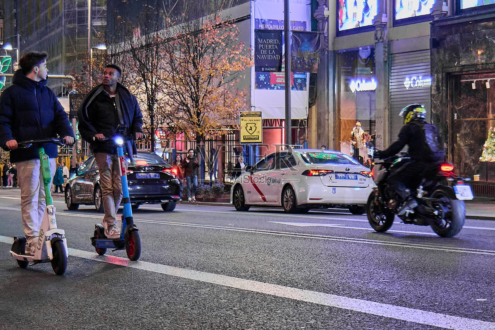 夜晚街道场景，摩托车和电动车穿行其间照片摄影图片