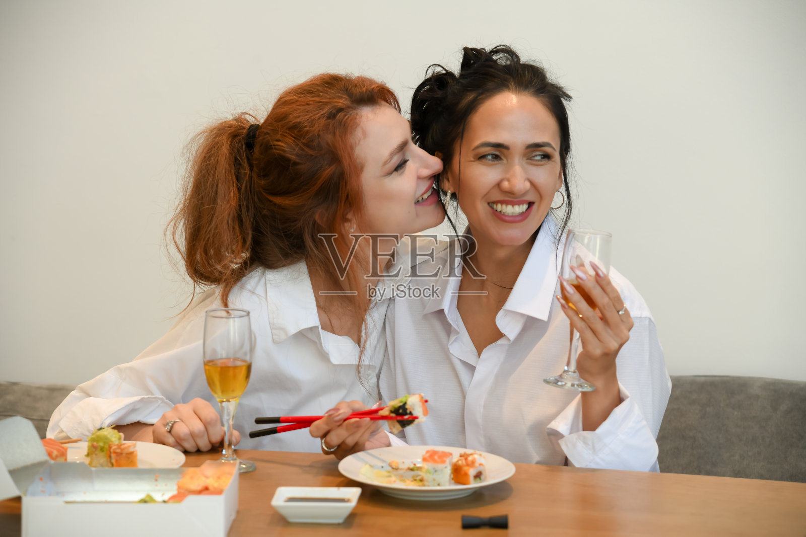 朋友们在家享受寿司和饮品，分享欢笑和快乐时光，度过轻松的聚会。照片摄影图片