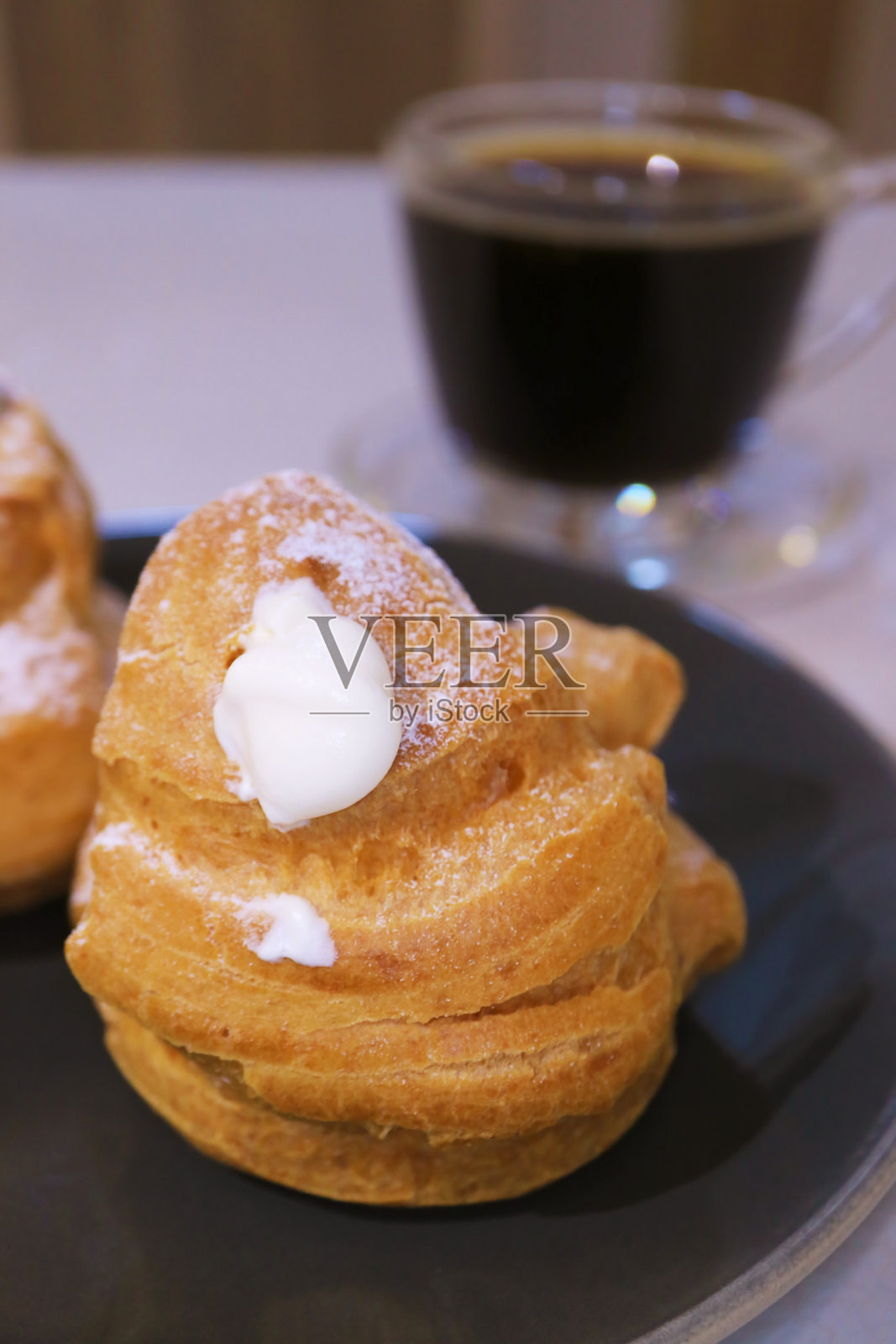 美味的法式奶油泡芙特写与一杯黑咖啡照片摄影图片