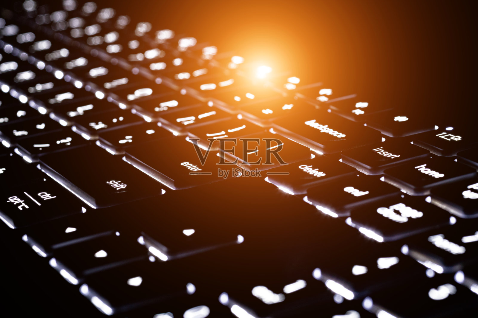 黑色背景下的背光键盘特写。模糊的键盘碎片。照片摄影图片