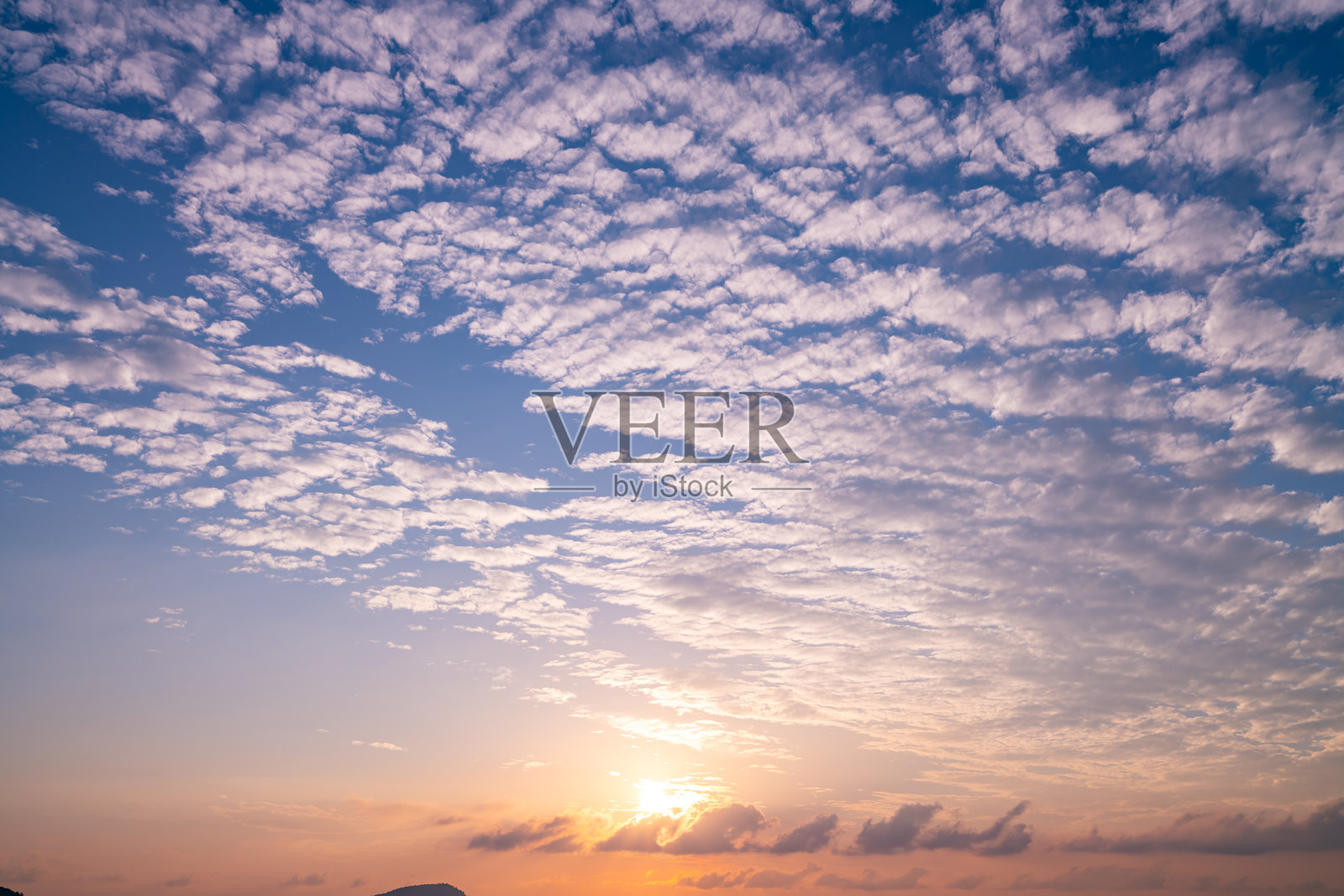 惊艳的多彩云彩在日落或日出时的天空中，映衬着海洋自然风光背景照片摄影图片