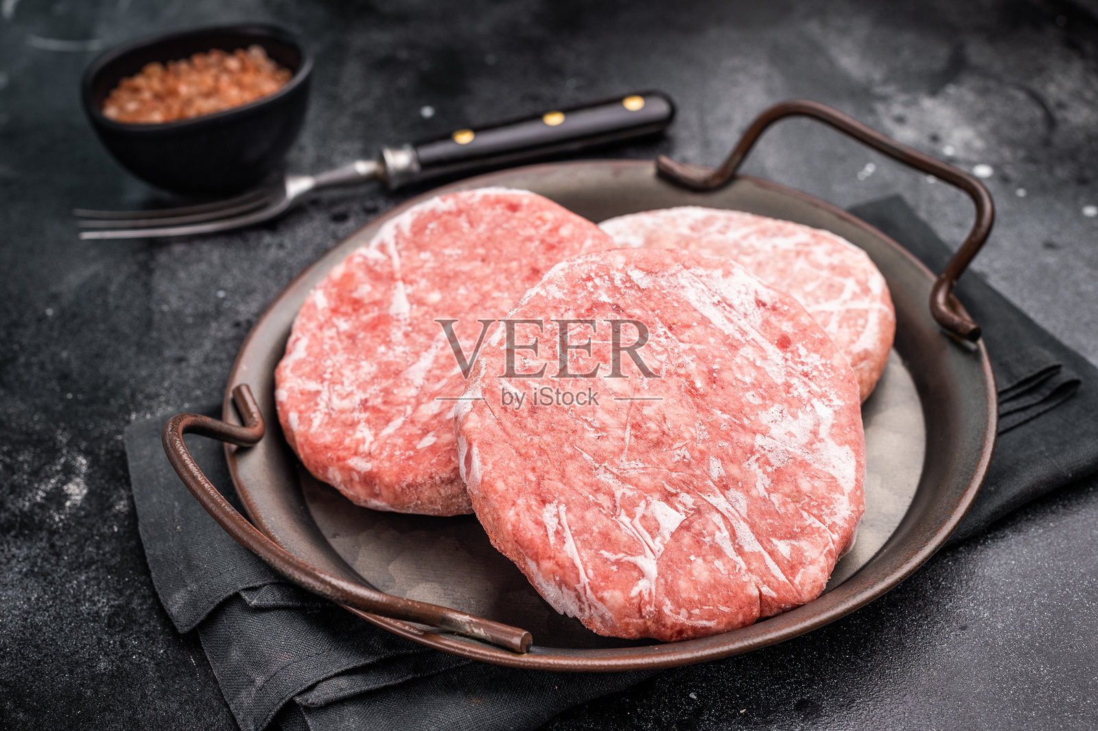 冷冻肉饼，猪肉和牛肉的绞肉用于汉堡。黑色背景。俯视图照片摄影图片