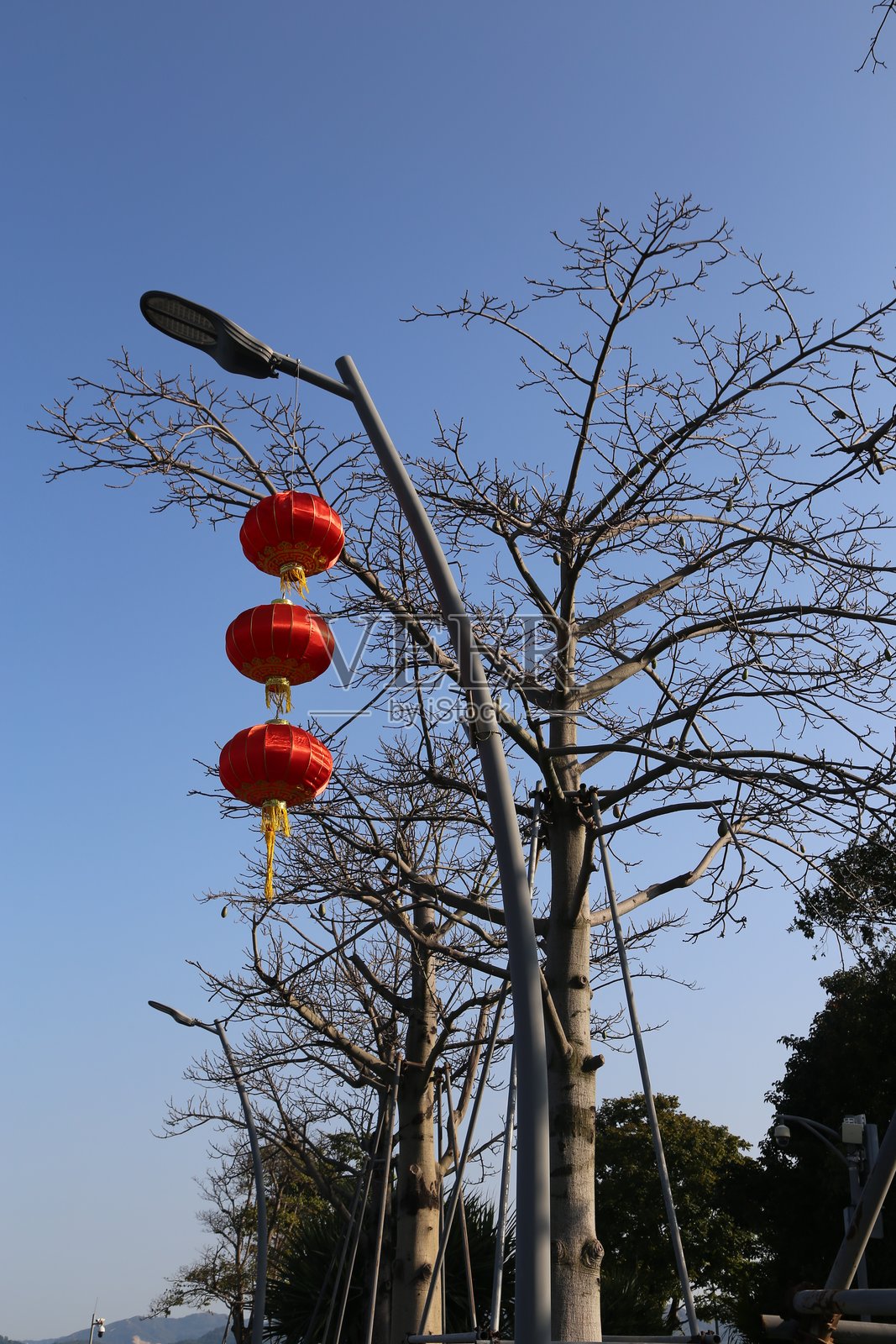 一盏街灯上挂着三个红色灯笼照片摄影图片