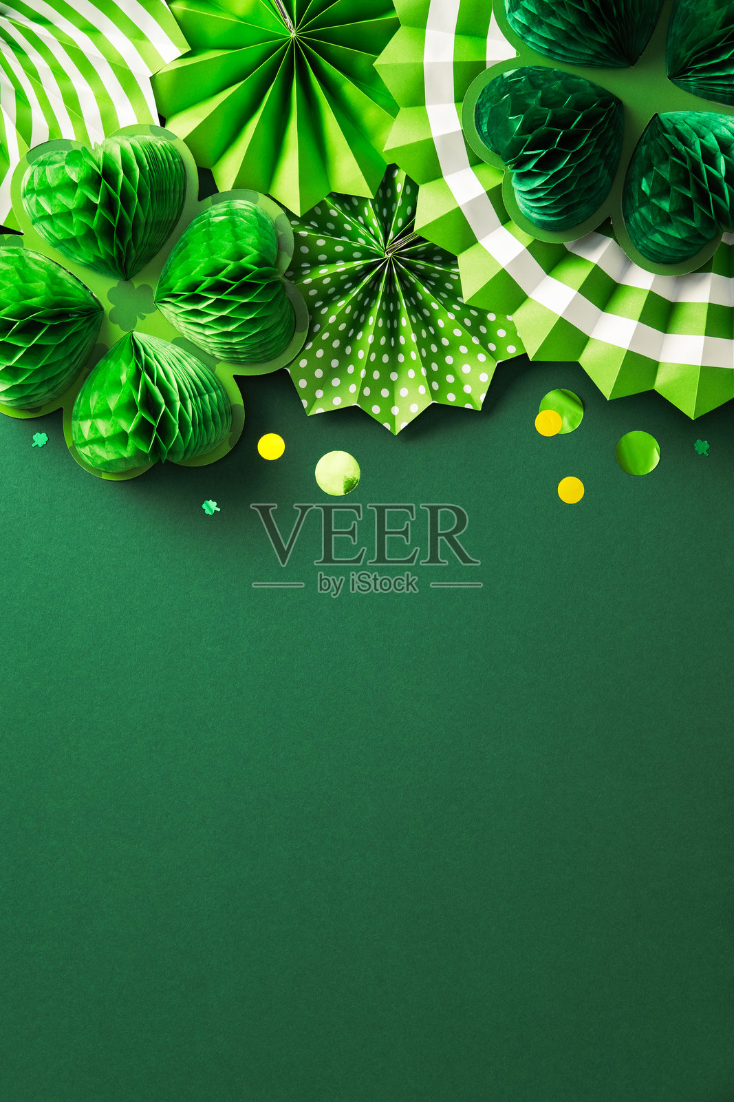 绿色圣帕特里克节背景，配有纸质三叶草、波点扇子和条纹花饰照片摄影图片