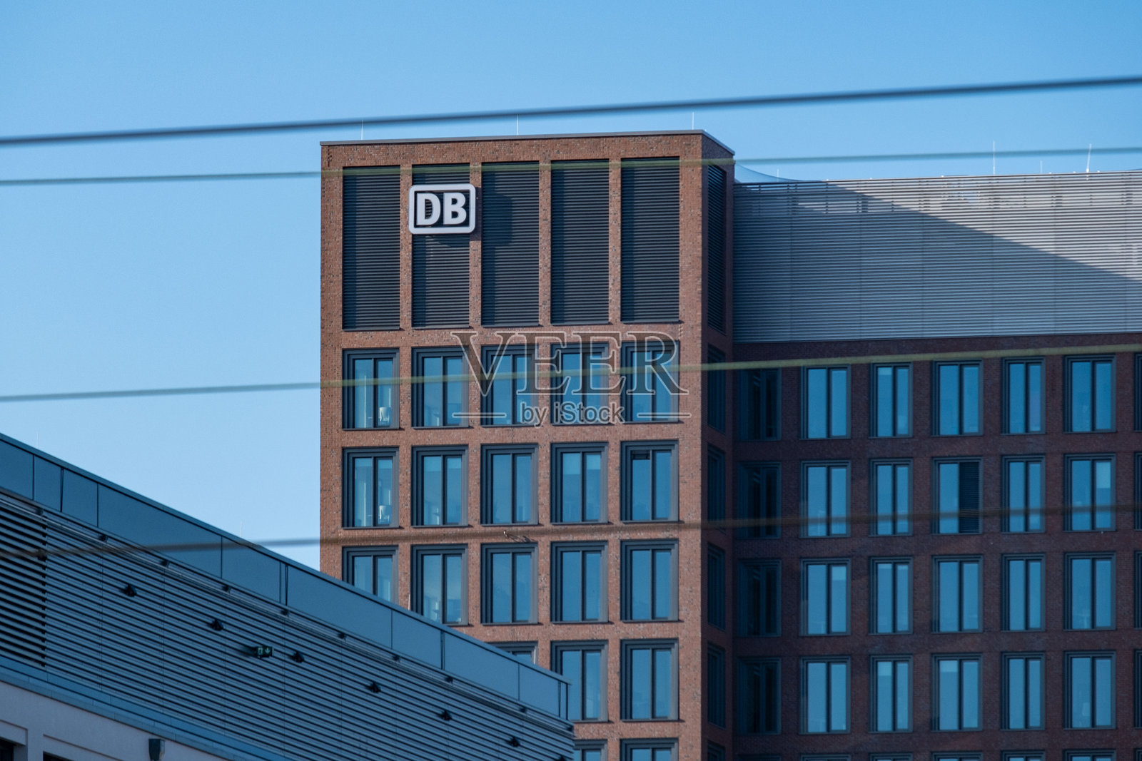 带有显著标志性DB标志的建筑在蓝天映衬下，企业建筑与玻璃外立面的交通和连接，法兰克福火车站 - 2025年1月19日照片摄影图片