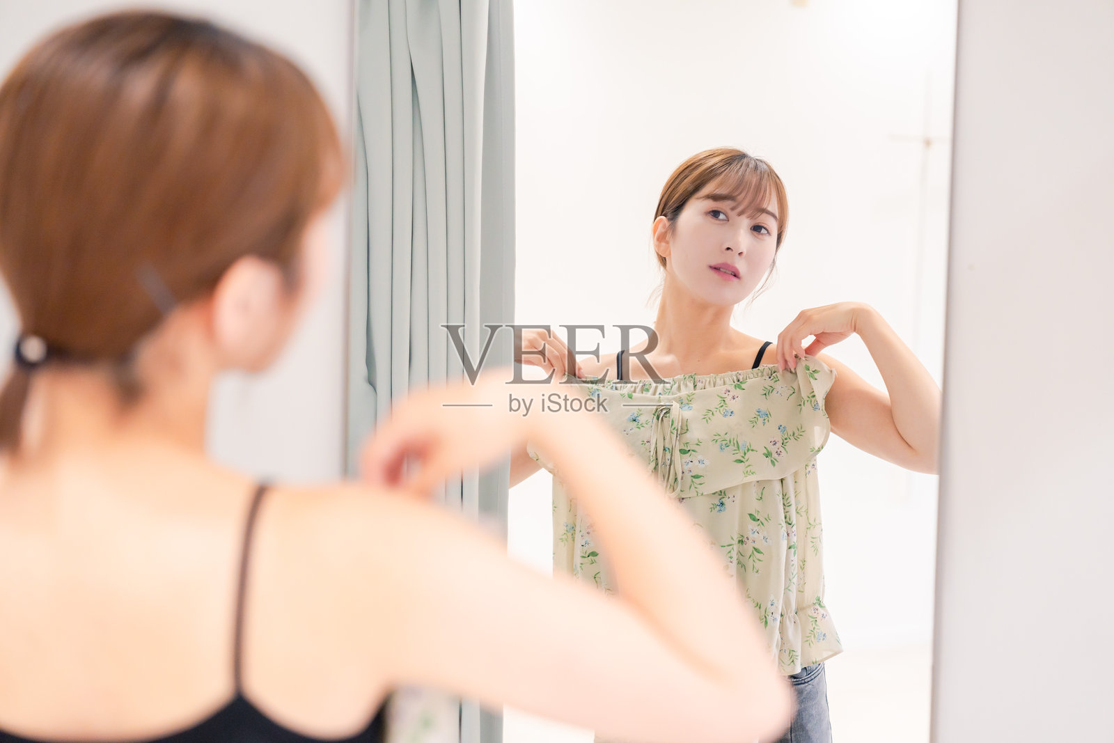 年轻女性在试衣间试衣服照片摄影图片