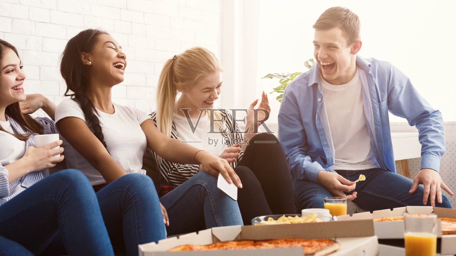 快乐的学生们在家里吃披萨并欢笑照片摄影图片