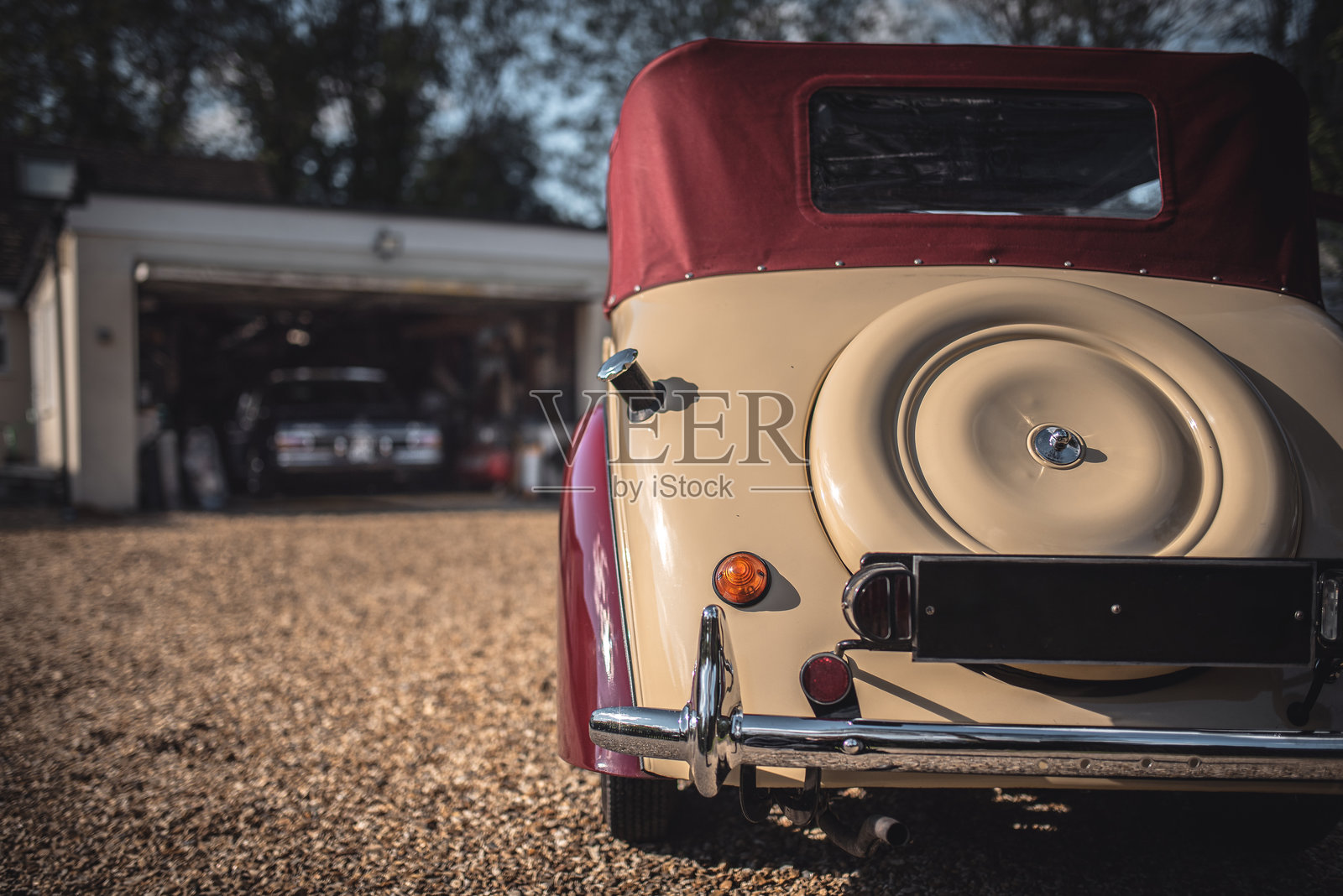 复古汽车停在车库背景前，另一辆德国豪华车停在旁边。西萨塞克斯，英国照片摄影图片