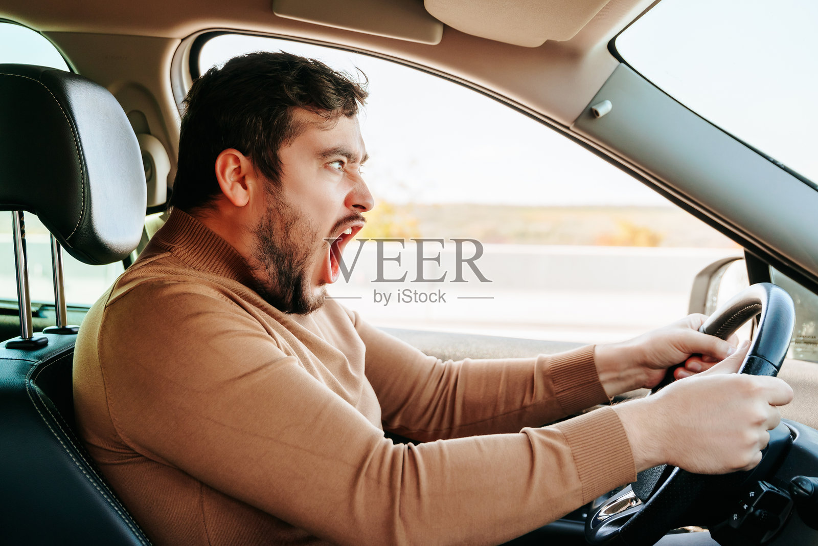 男司机正试图紧急刹车，同时大喊并变得愤怒。照片摄影图片