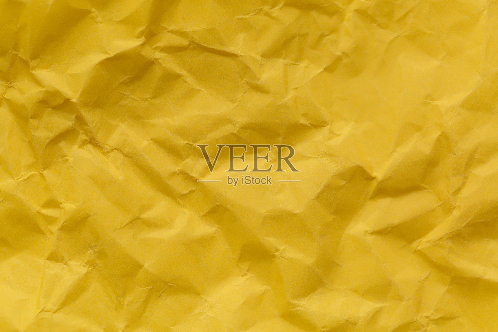 黄色皱纸纹理的特写，皱折的黄色纸张特写。细致的照片纹理背景。照片摄影图片