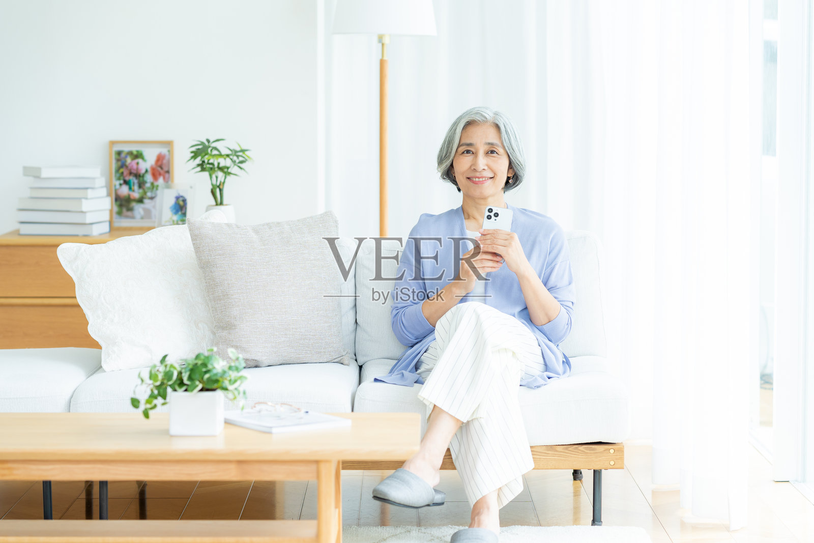 老年女性在客厅使用智能手机照片摄影图片