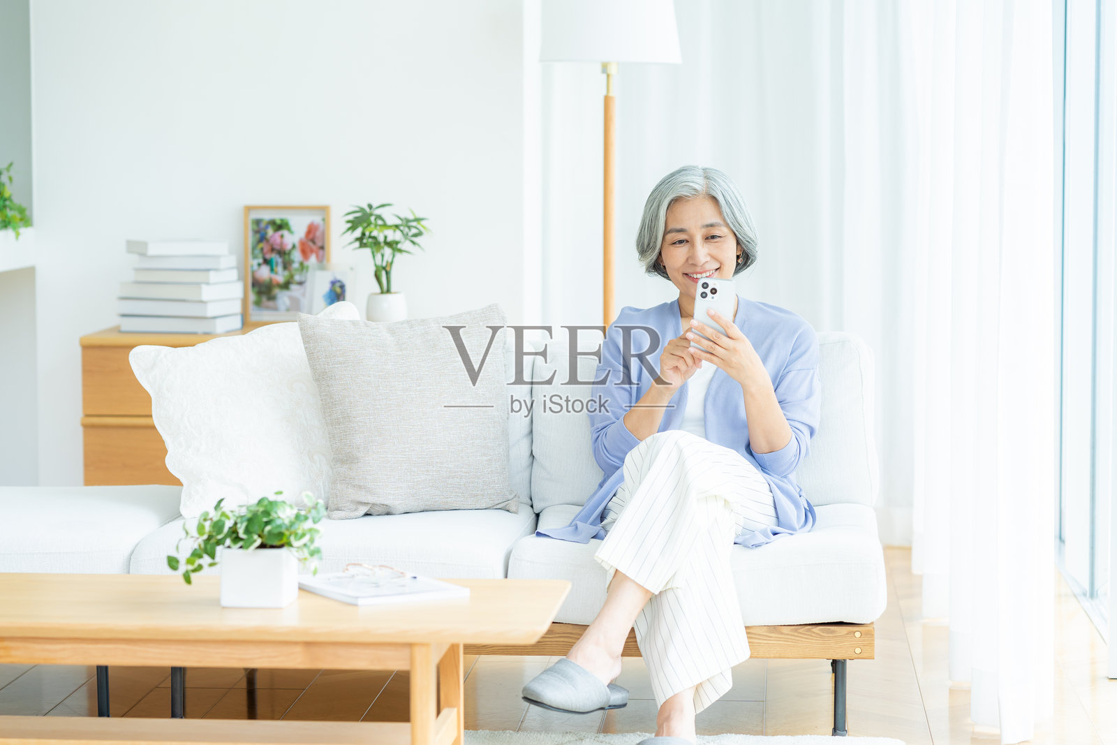 老年女性在客厅使用智能手机照片摄影图片