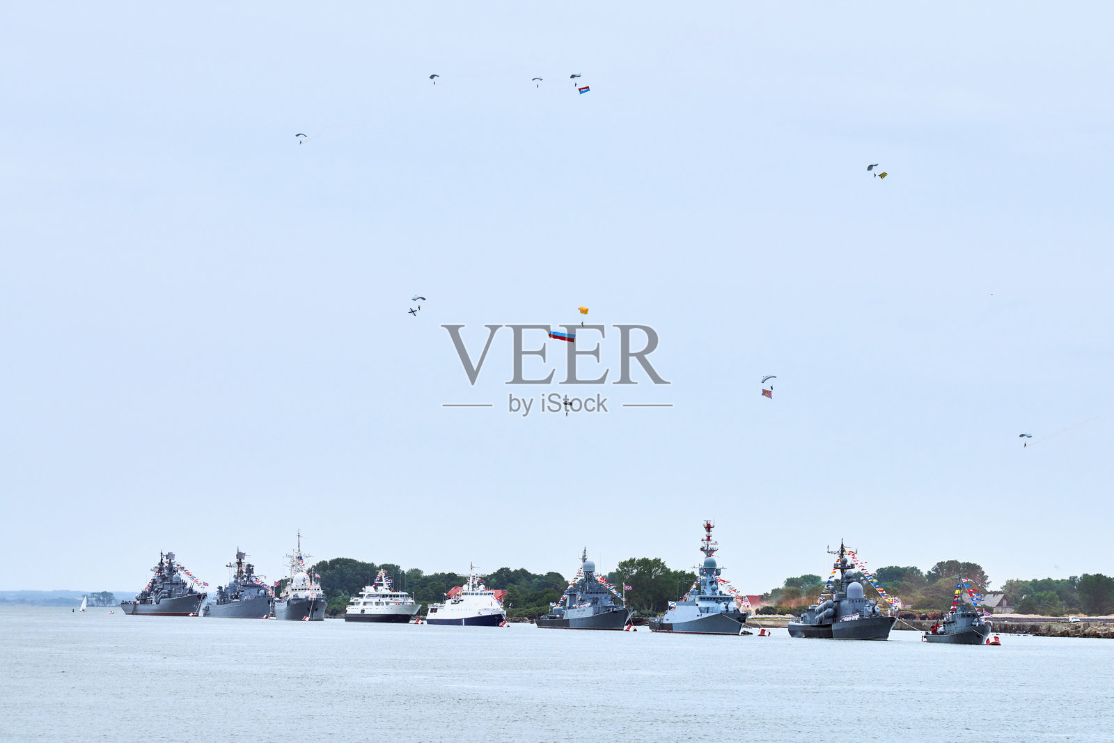 空降部队伞兵在海岸线上的海军舰艇阅兵中飞扬俄罗斯国旗照片摄影图片