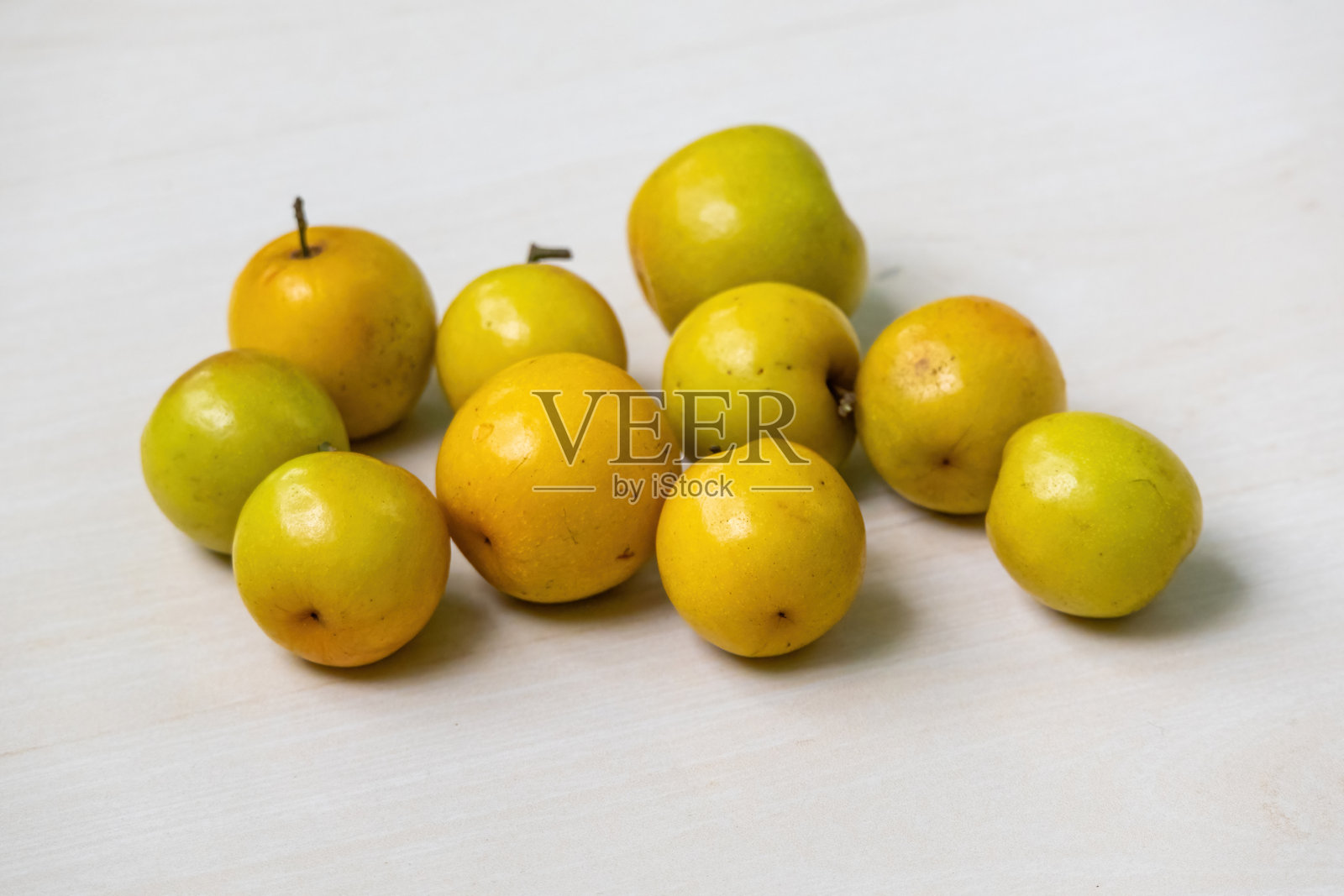 新鲜成熟的梅子果实静静地放在浅色木质表面上。在孟加拉国，这种水果被称为Boroi或Kul，它也被称为印度枣、中国枣或中华苹果。照片摄影图片