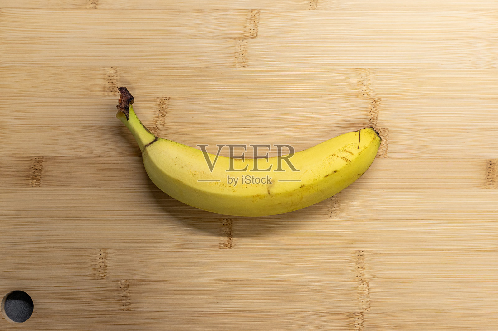 一根成熟的香蕉放在木质切菜板上照片摄影图片