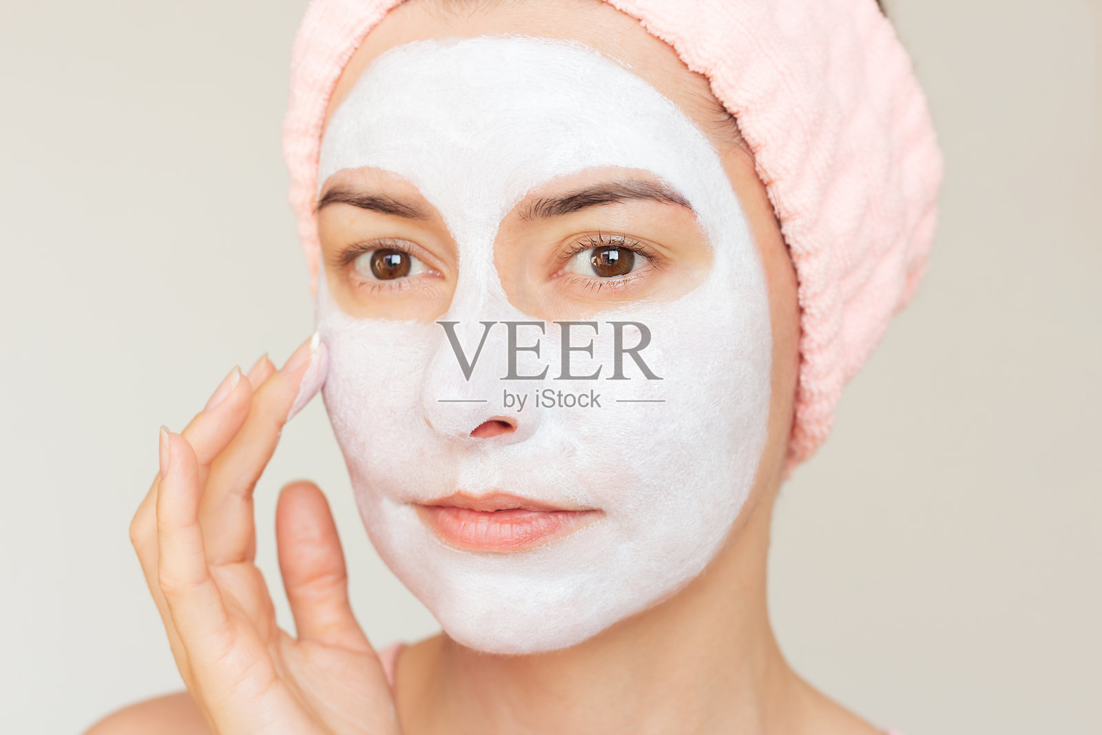 年轻美丽的白人棕发女性，戴着粉色头带，脸上带着白色口罩。照片摄影图片