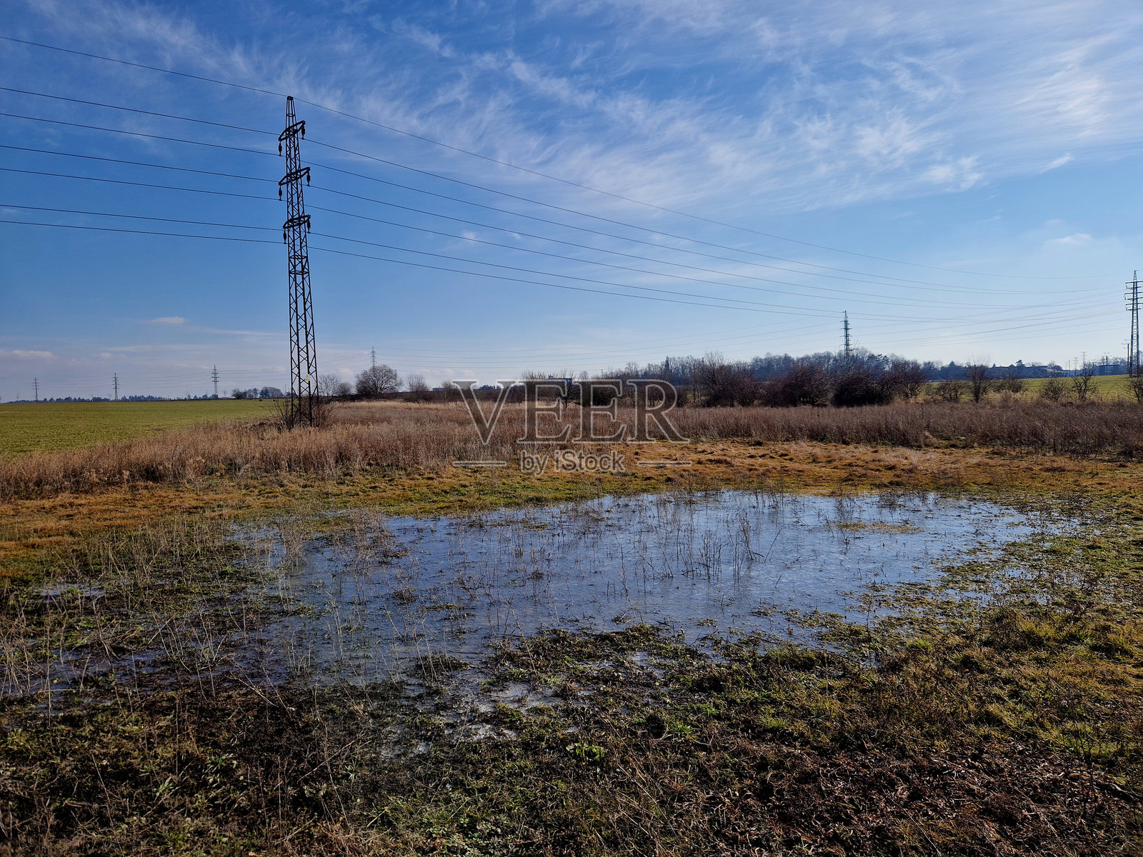 土壤过于紧实和不透水，导致在雨季和洪水期间无法吸收水分。公园的草坪上形成了一个湖泊，水逐渐渗透。长时间的洪水对草坪造成了损害。水的冲击。照片摄影图片