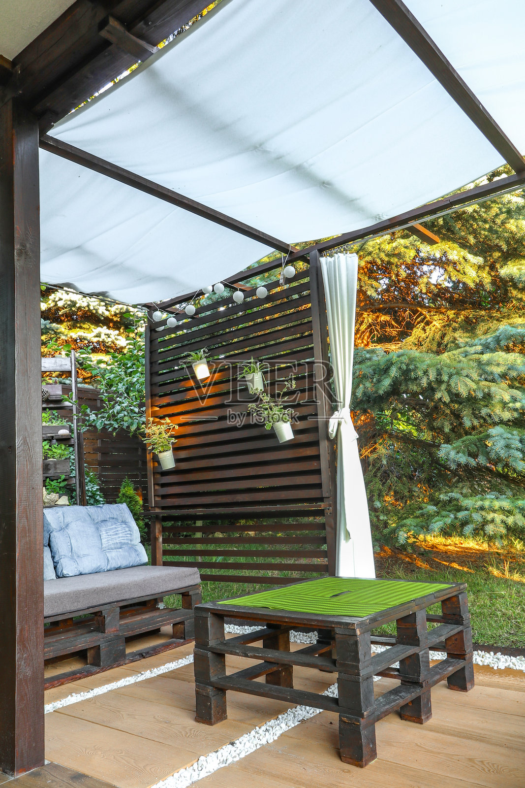 在花园里搭建木质凉亭，自己动手，家中的休息场所，充满创意的花园，波兰凉亭中的白色窗帘照片摄影图片