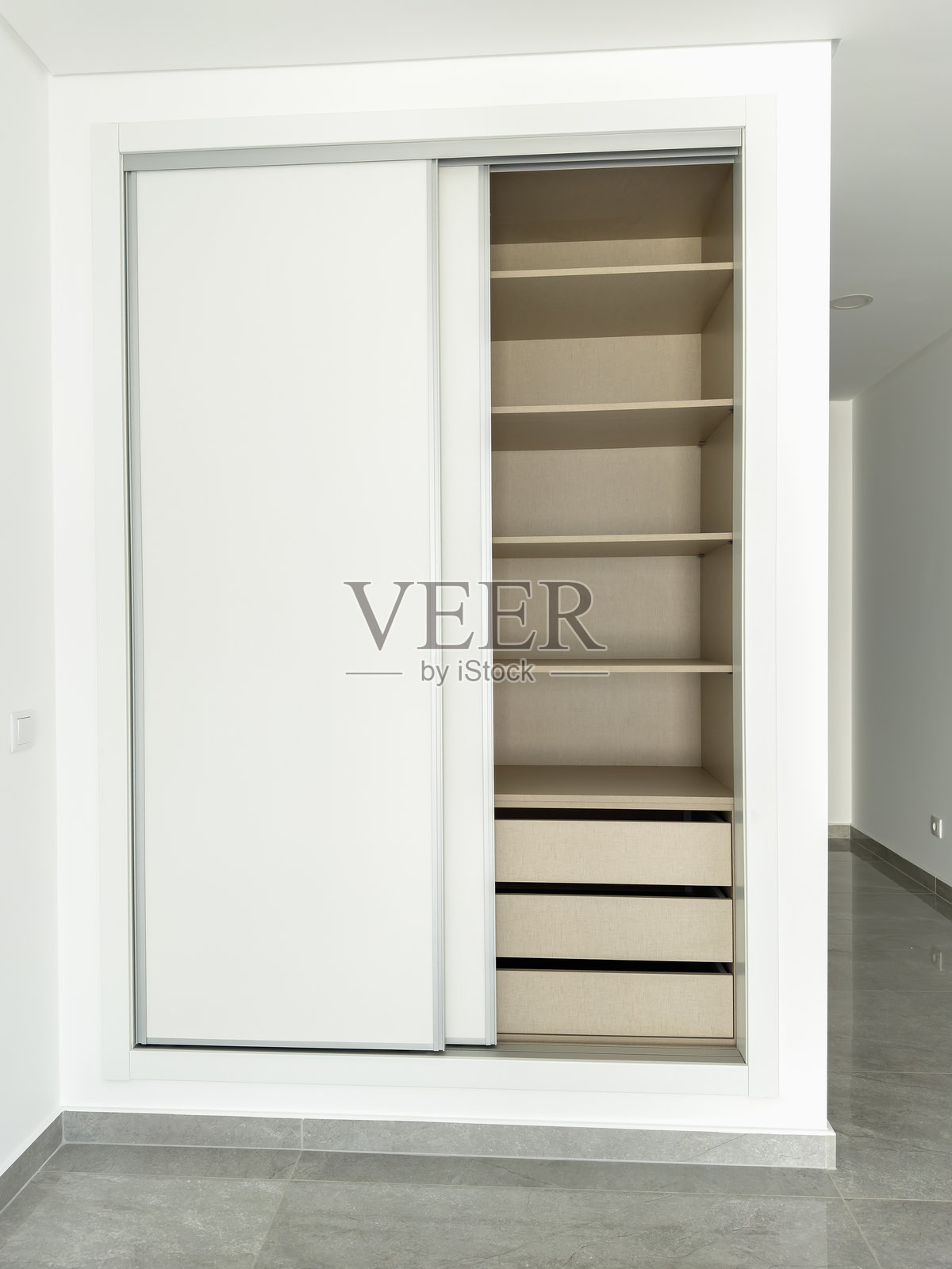 极简主义衣橱，配有有序的储物系统，包括架子和抽拉式抽屉。照片摄影图片