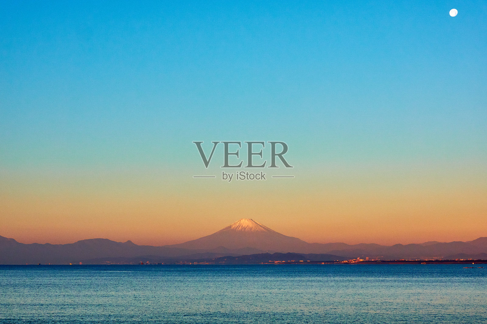 日出时分，清澈天空下雪山与海洋的美丽景色照片摄影图片