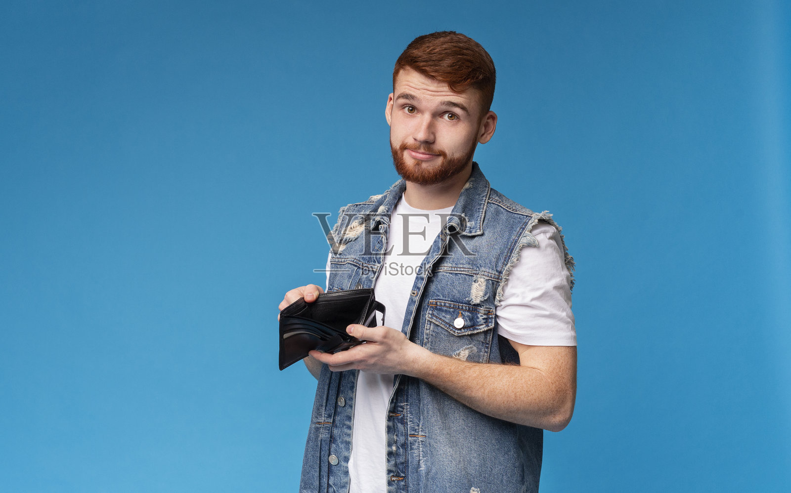 悲伤的千禧一代男子向镜头展示他的空钱包照片摄影图片