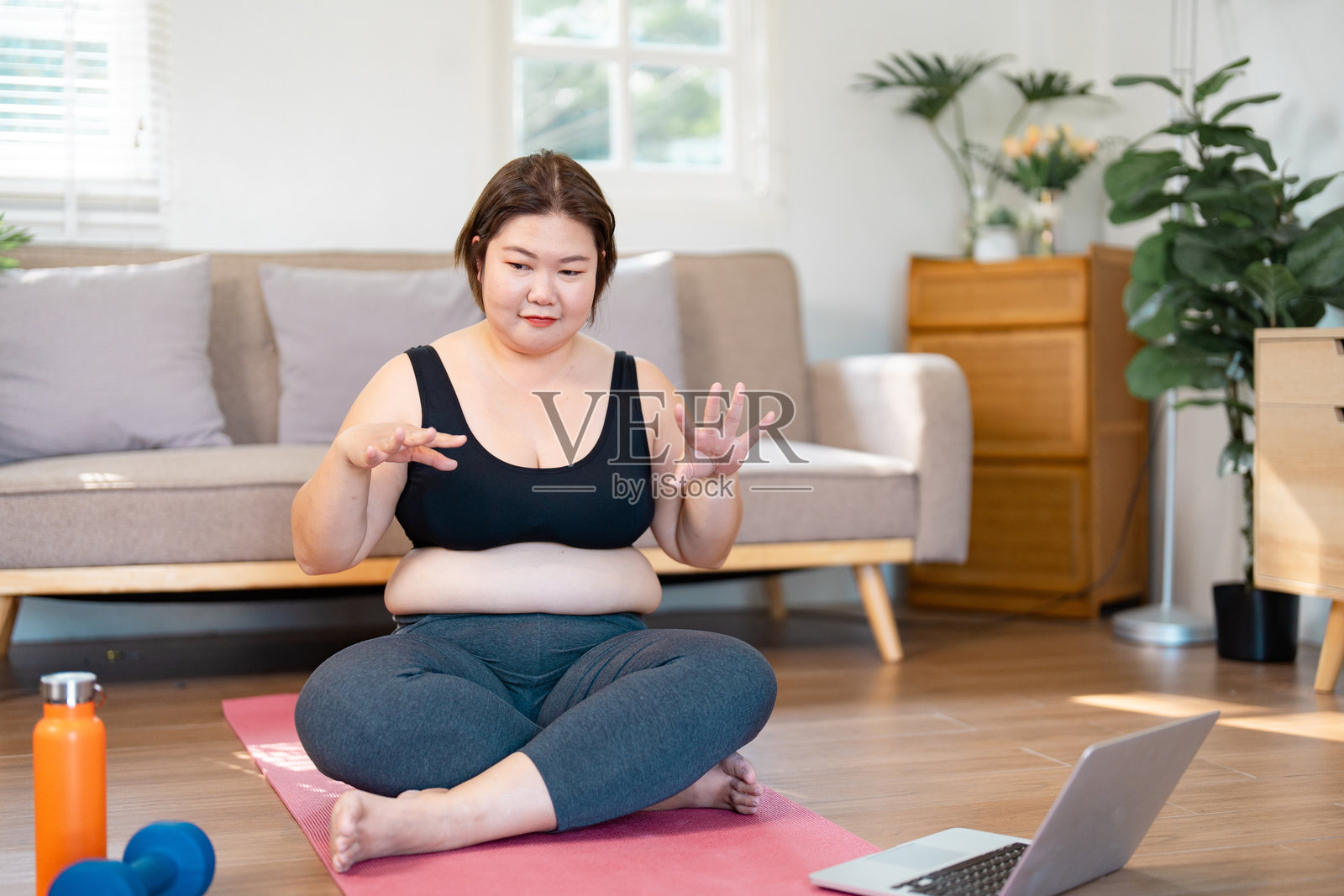 一位丰满女性在家中练习正念和冥想，专注于健康和生活方式。照片摄影图片