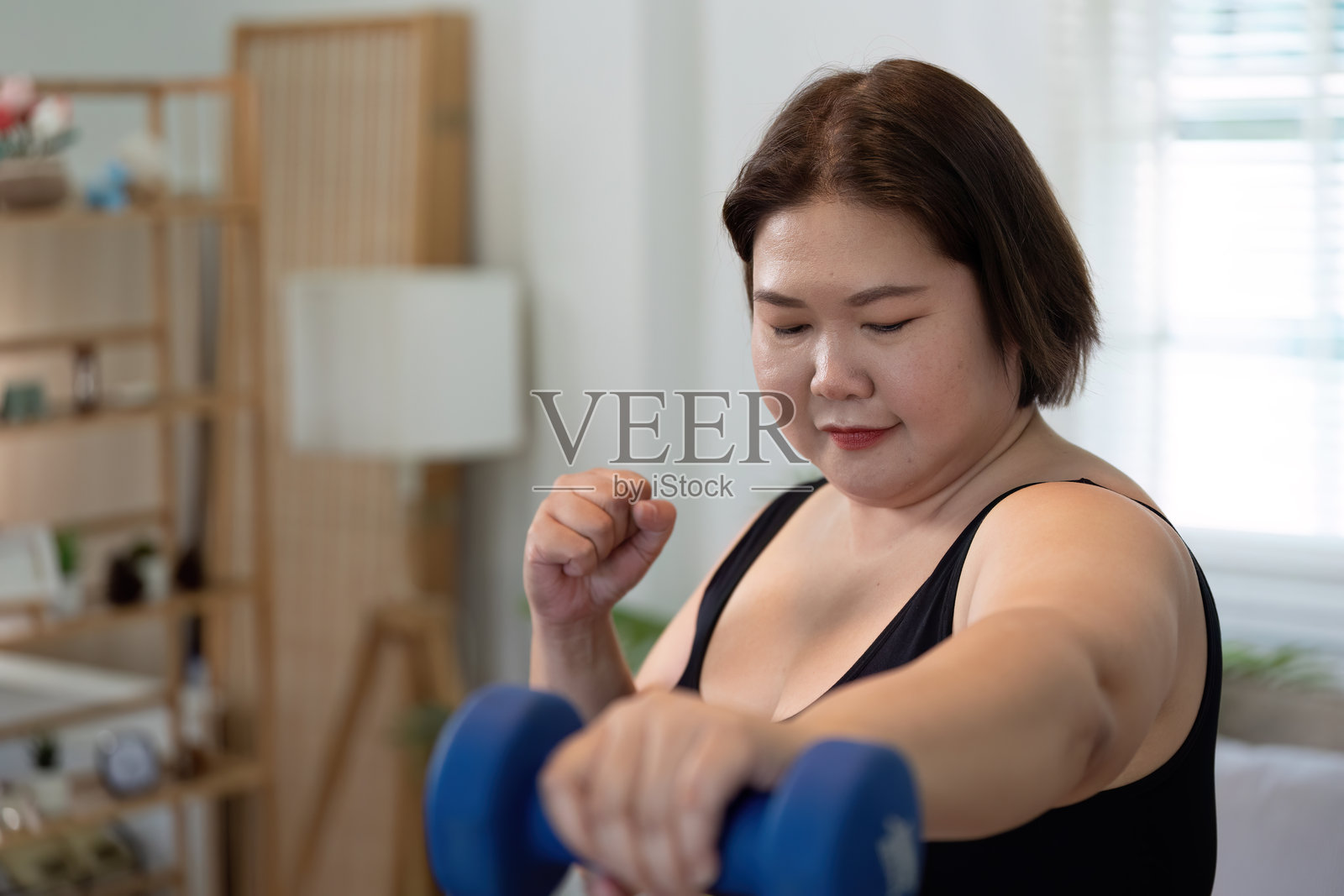 在家进行力量训练的超重女性，专注于健身和健康照片摄影图片