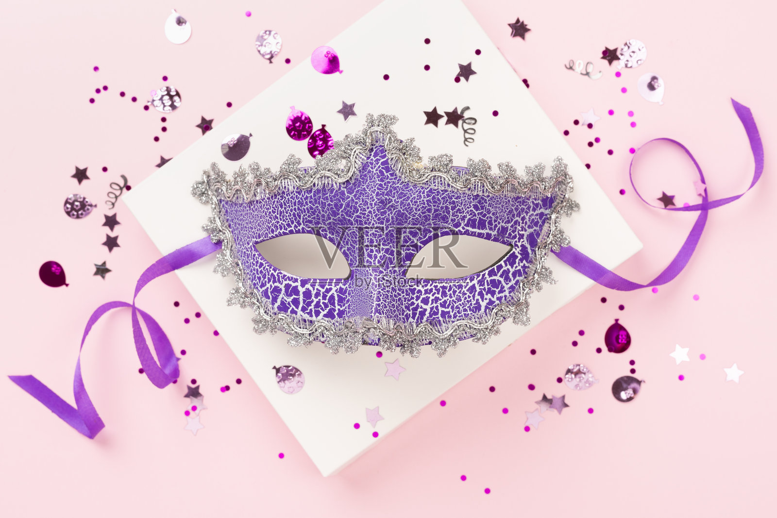 明亮的嘉年华面具与五彩纸屑在彩色背景上，俯视图照片摄影图片