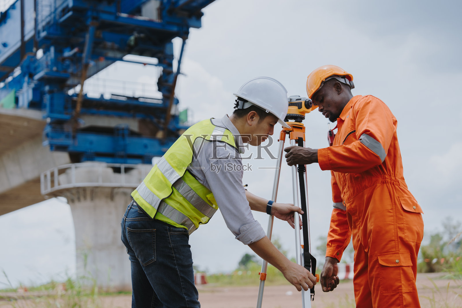 测量工程师在施工现场使用经纬仪进行测量。测量员查看施工现场或进行安全检查。照片摄影图片