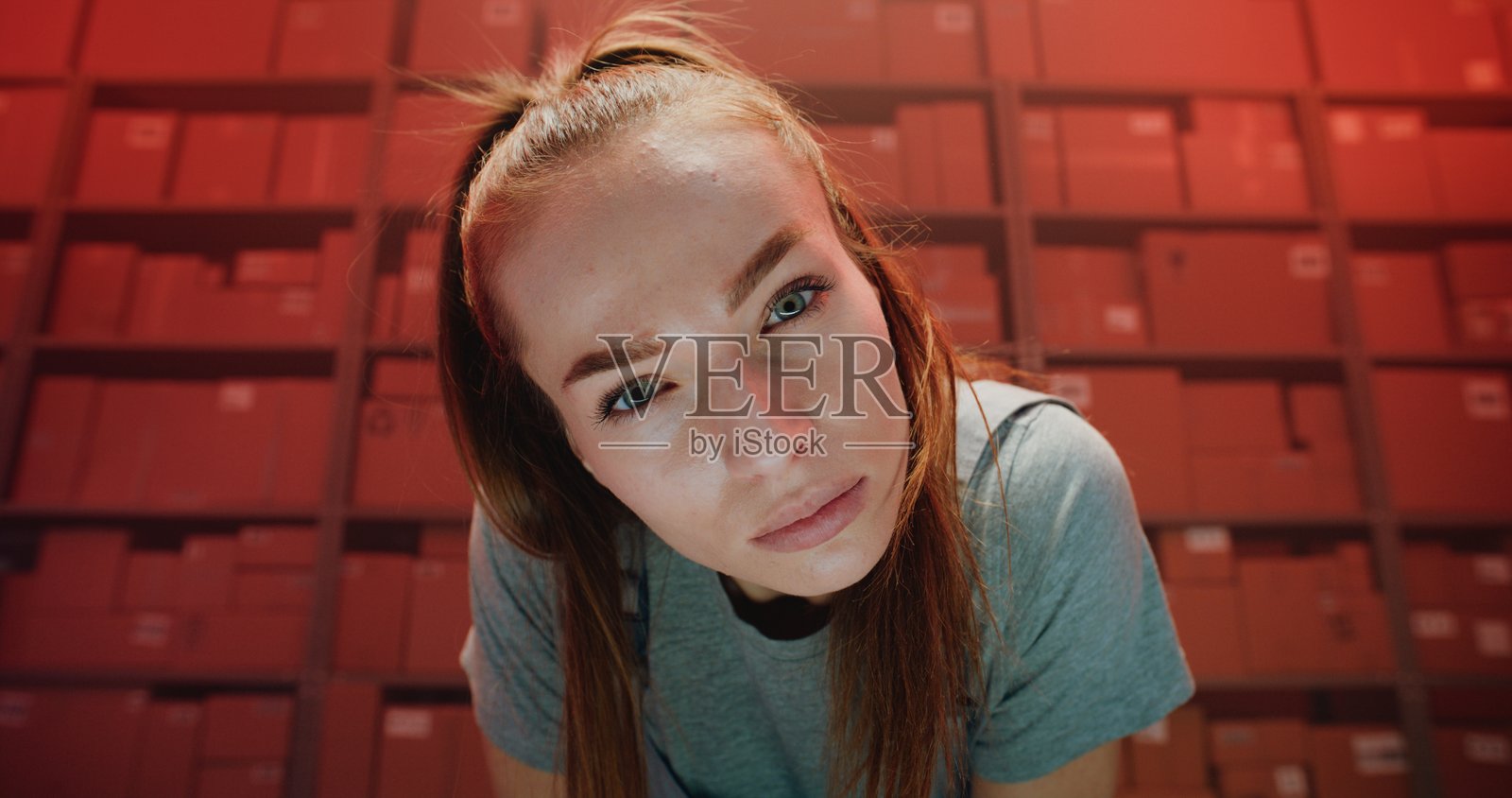 身穿制服的严肃女性物流专员在仓库零售设施中注视镜头照片摄影图片