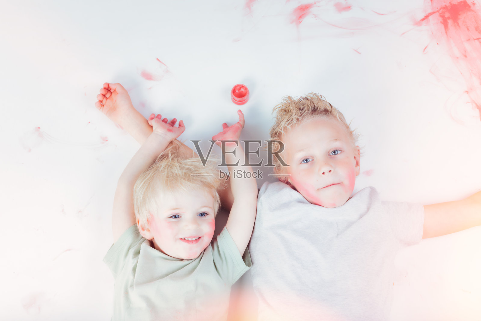 两个金发儿童躺着玩化妆品照片摄影图片