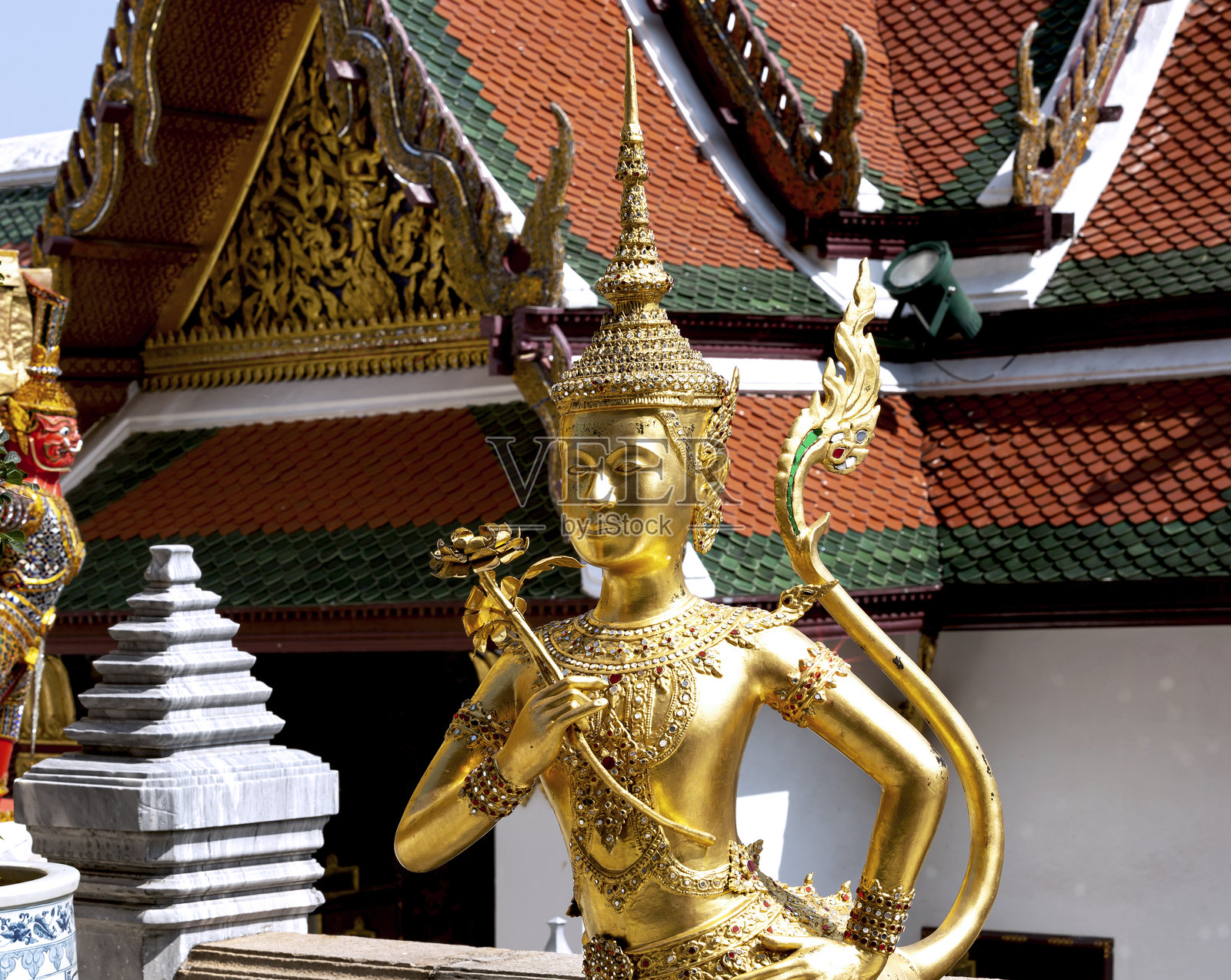 手持花朵的精致金色宗教雕像照片摄影图片