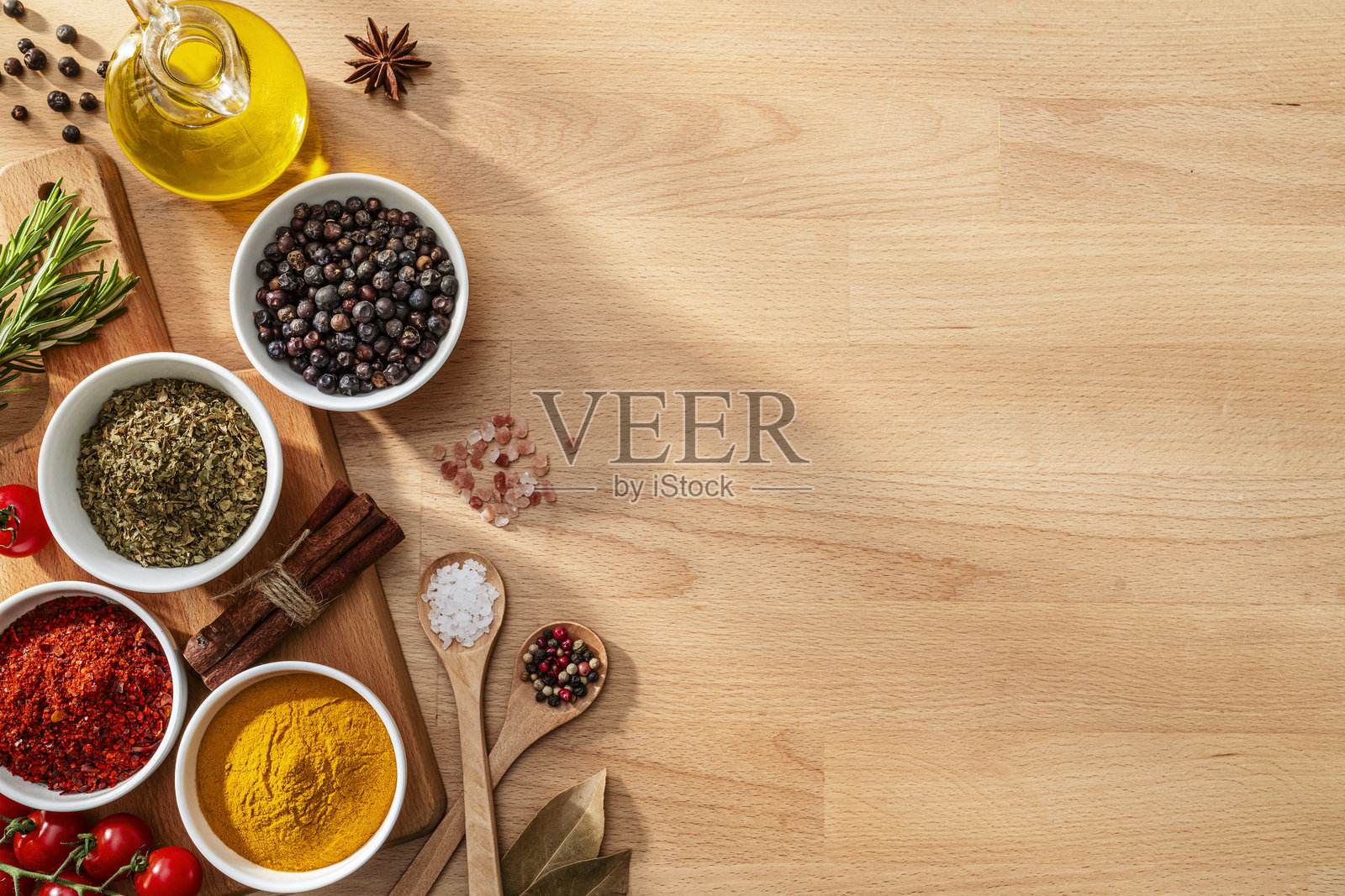 木质背景左侧摆放的香料和草药平铺图。留白空间。照片摄影图片