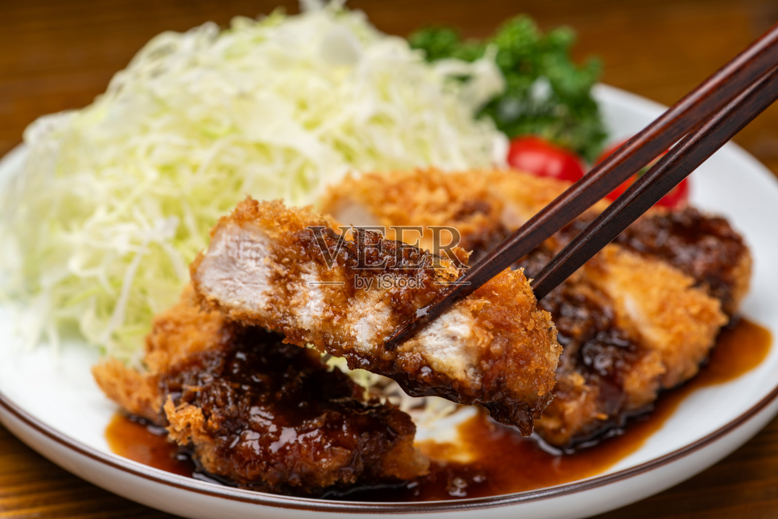 用筷子夹起酥脆的猪排照片摄影图片