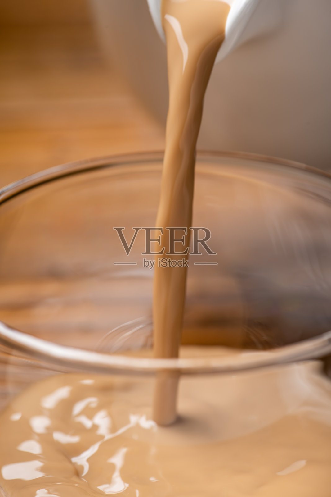 将咖啡牛奶倒入玻璃杯中照片摄影图片