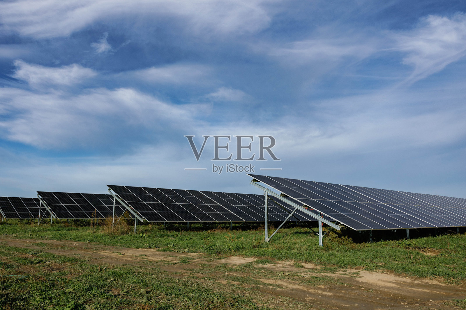 在阴云密布的天空下，太阳能电池板提供清洁能源照片摄影图片